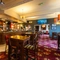 Interior dining area of a pub with a bar and a TV.