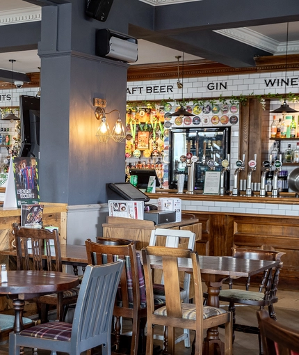 Interior dining area of a pub with a bar.