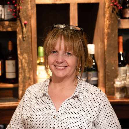 A portrait image of Kayte within the interior of The Blue Cap.