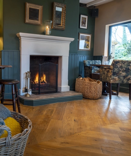 A fireplace amongst a seating area of The Bulls Head.