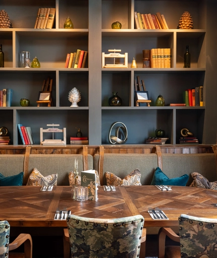 A table in front of a bookcase in the restaurant of Himley House.