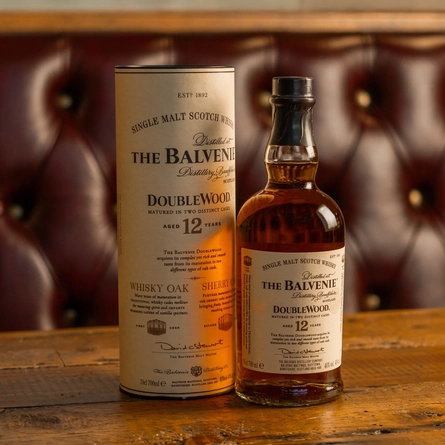 A bottle of Balvenie Whisky on a table next to a presentation box.