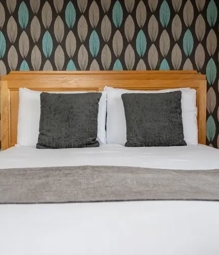A interior double hotel bedroom with bedside tables and lamps at The Commodore.