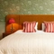 Hotel double bed with scatter cushions and bedside tables either side with lamps on top