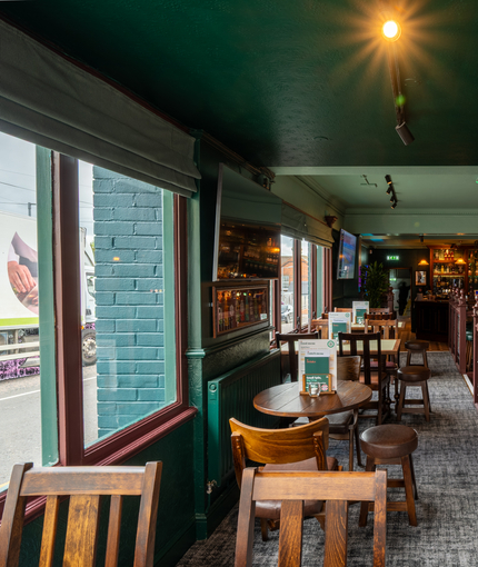 An interior restaurant seating area at The Junction, with TVs and framed artwork on the walls.