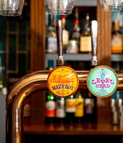A close up view of the beer taps for Hazy Day, Level Head, and Old Mout Berries & Cherries; on the bar at The Talbot.