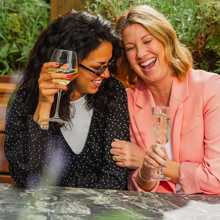 An image of people enjoying various drinks within the exterior beer garden seating area at a Crafted venue.