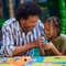 An image of a child and a man participating in crafts at a Wacky Warehouse.