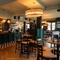 The bar and interior restaurant seating area at The Richmond Arms, with TVs on the wall, and gaming machines.