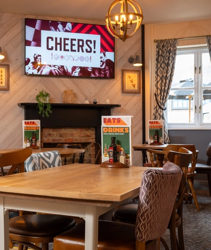 The interior restaurant and seating area with TV at The Woodlands.