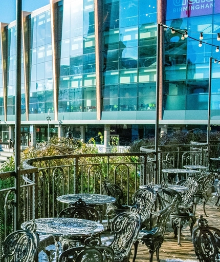 Exterior of the venue with seats overlooking the river with a bridge