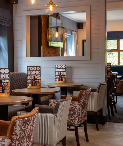 An interior restaurant seating area at The Wall's End, with upholstered chairs and booth seating.