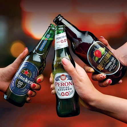 A bottle of 0% Kopparberg, 0% Peroni and 0% Heineken being cheersed.