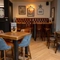 An interior restaurant seating area at The Wall's End in Wallsend, with upholstered booth seating, an illuminated dartboard, and framed artwork and football shirts on the walls.