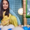 A child smiling at the camera in a ball pit in an indoor play area.