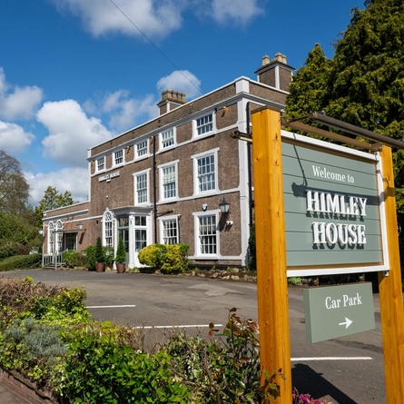 The exterior facade and car park with venue signage at The Himley House.