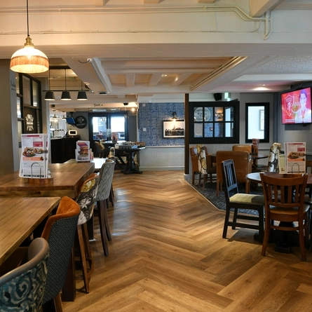 The interior restaurant seating area with TV at The Biscot Mill.