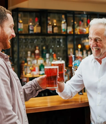 Two men with drinks at a bar