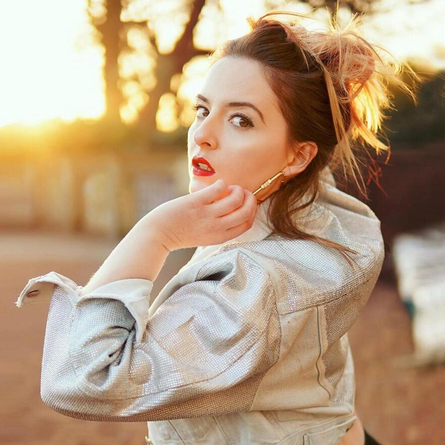 A image of a performer outside posing for the camera, used to advertise 'whats on' in Crafted venues.