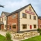 The exterior facade, signage and beer garden seating area with wooden picnic tables, at The Flying Horse in Heald Green.