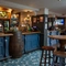 The blue, wood panelled bar inside The Royal Oak in Bishops Cleeve, with a large beer barrel built into the counter.