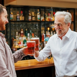 Two men with drinks at a bar