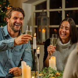 An image of 3 adults enjoying sparkling white wine drinks within the interior restaurant seating area at a Venture Hotel venue.