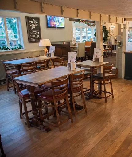 High seats in a bar area with a bar. The room is decorated for Christmas