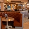 The bar and interior seating area at The Weathervane, with a circular booth seat around a round wooden table.
