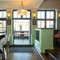 Interior of entrance door with high tables on either with bar stools