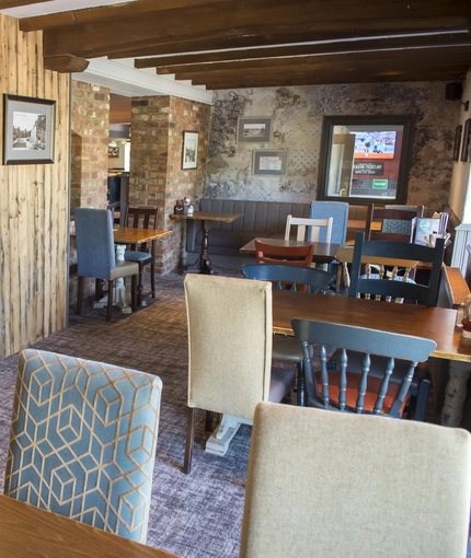 Interior dining area of a pub with a TV.