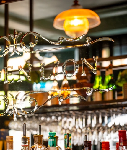 A close up view of a mirror inside The Golden Lion, etched with a filigree pattern and the words "Golden Lion".