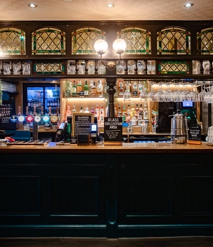 The interior bar with advertising signage and glass water dispenser at The Three Crowns.