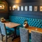 An interior restaurant seating area at the Tredegar Arms, with an upholstered booth seat, and framed artwork on the wall above it.