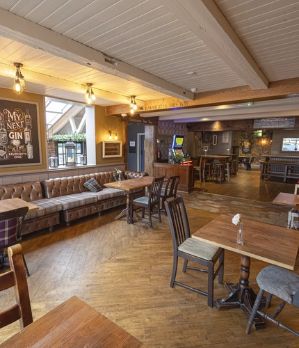 Interior dining area of a pub with a gambling machine.