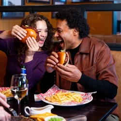 A family enjoying a meal and drinks in the interior restaurant from the new Spring/Summer menu at Flaming Grill.