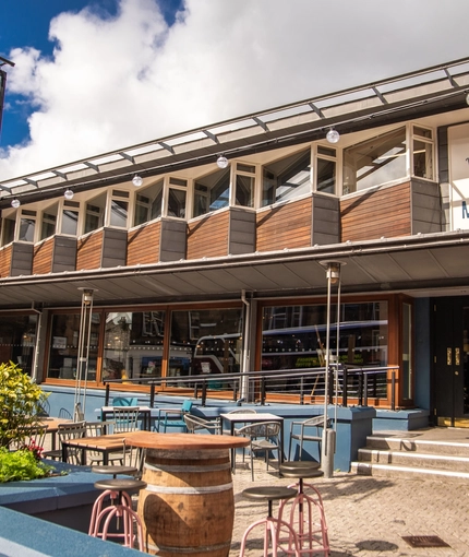 The exterior facade, signage and beer garden seating area of The Merlin in Edinburgh.
