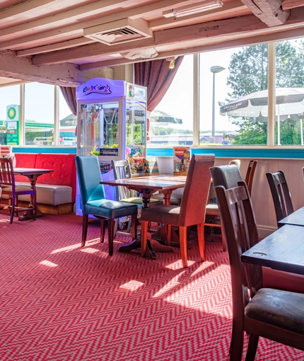 Interior dining area of a pub with a claw machine.