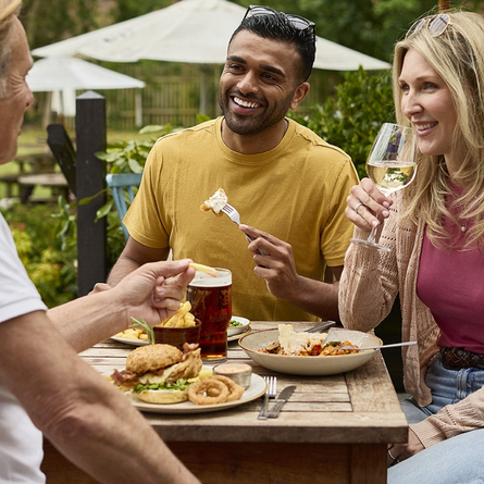 An exterior shot of people enjoying summer beers in a beer garden at a Chef & Brewer venue.