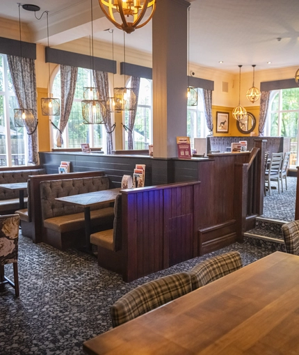 Interior dining area of a pub with a claw machine.