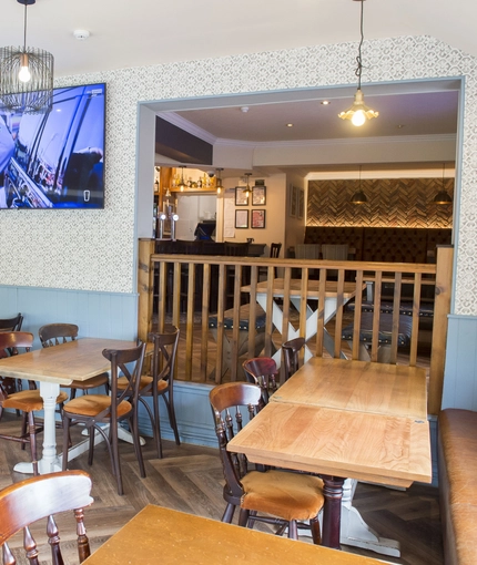 Interior dining area of a pub with a TV.