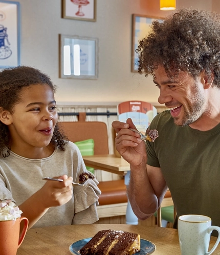 Dad and daughter eating a slice of cake