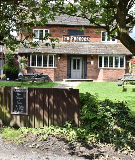 The exterior and part of the beer garden of The Peacock Inn.