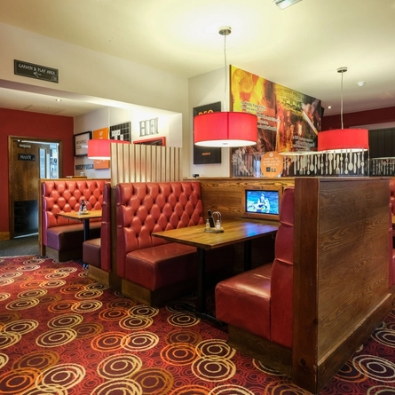 The interior restaurant seating area booths with TV screens at The Hardy Pick.