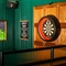 A close up view of a dartboard and framed artwork on a wall inside the Lord Raglan.