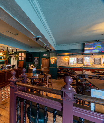 The wood panelled bar, and interior restaurant seating area at The Junction, with a TV on the wall.