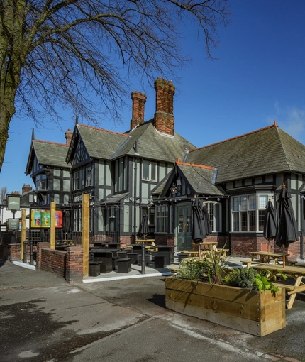 Exterior beer garden with wooden picnic benches