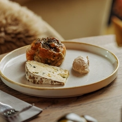 An advertising image of a Cheese Night dish showing a selection of cheeses within the interior restaurant and seating area at The Foundry Bell.