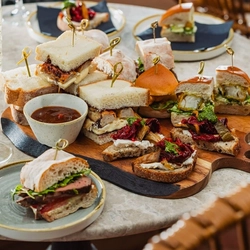 A variety of grazing board sandwich sharer dishes sat on a table within the exterior beer garden seating area at a Crafted venue.
