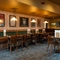 An interior restaurant seating area at The Richmond Arms, with a long upholstered booth seat along one side of the room; and framed artwork on the walls.